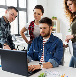 A small team gathered around a laptop