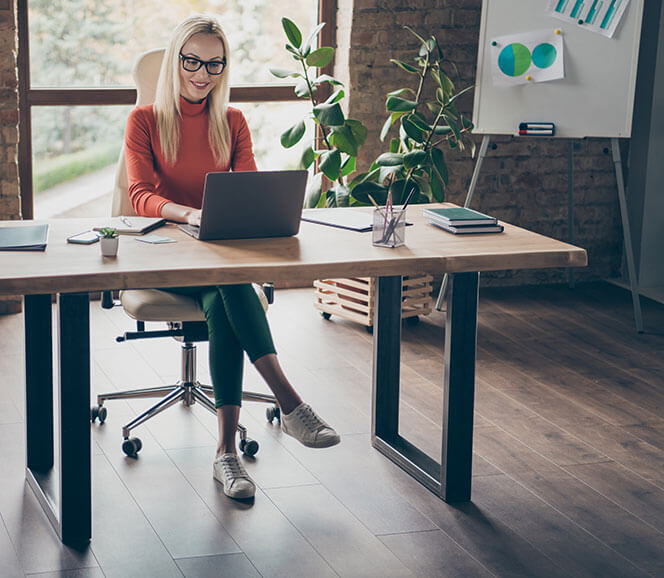 A business owner working at a desk in a bright studio